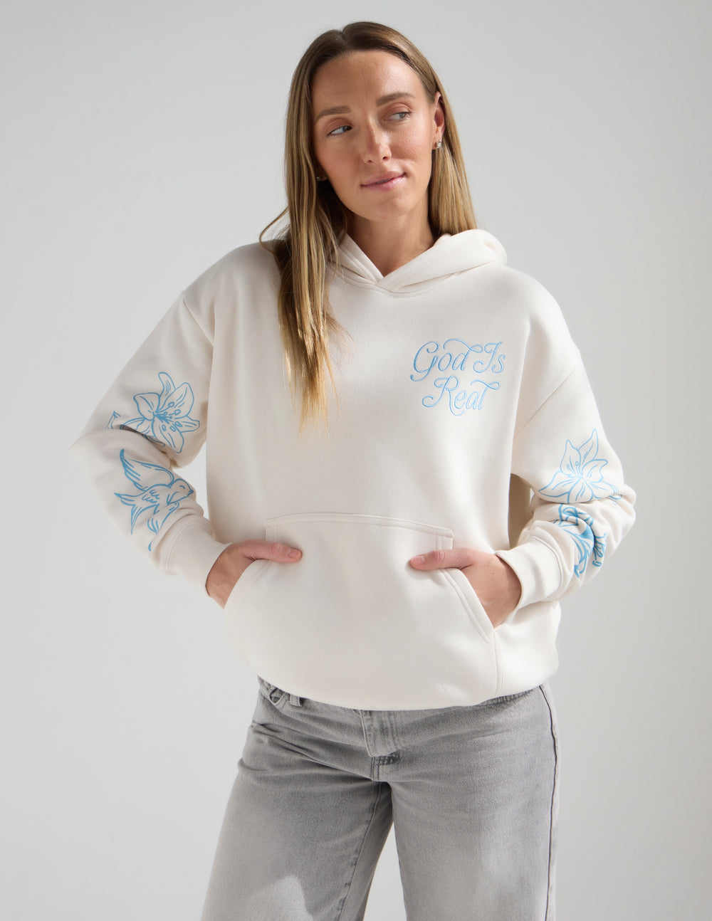 Unisex off-white hoodie with blue “God Is Real” chest print and front pocket