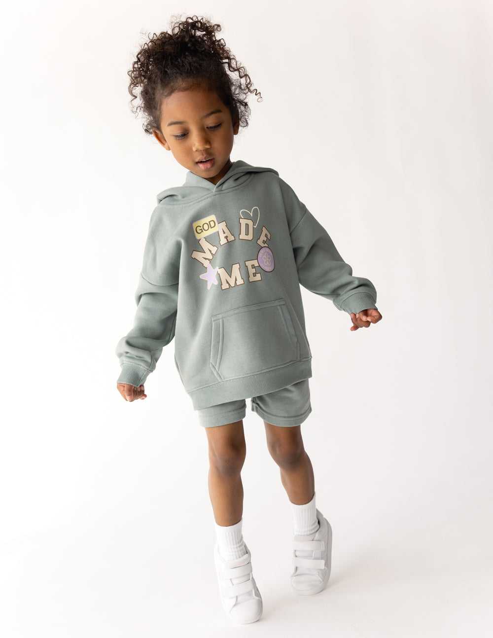 Kids sage green hoodie with hood, kangaroo pocket, and "God Made Me" graphic.