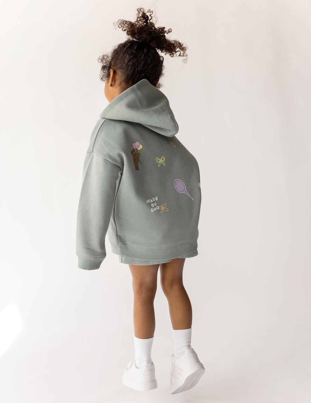 Kids sage green hoodie back with small icon prints and "Made by God" text.