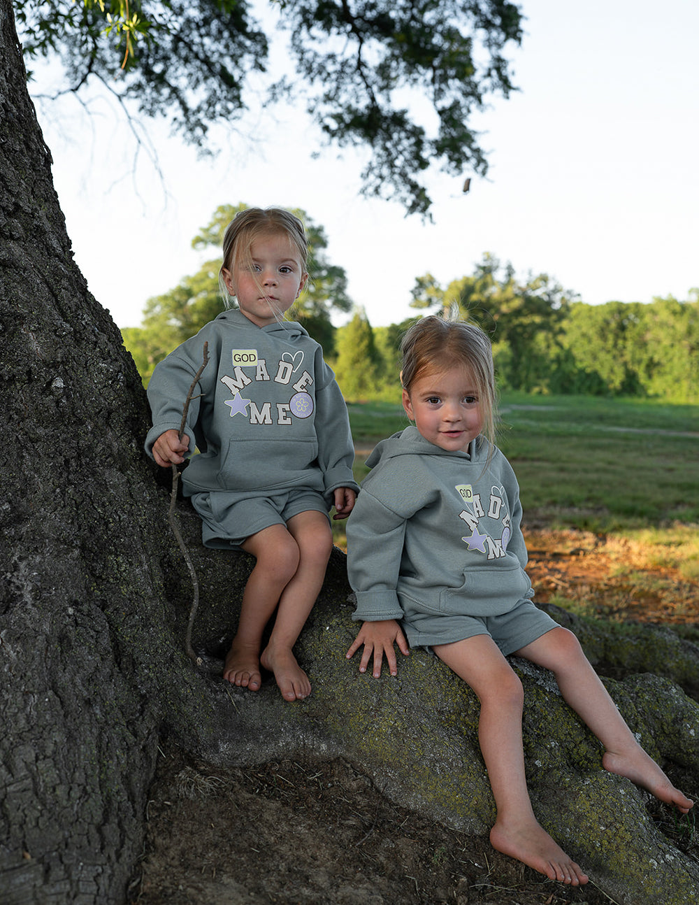 Kids sage green hoodie with hood and "God Made Me" front graphic.