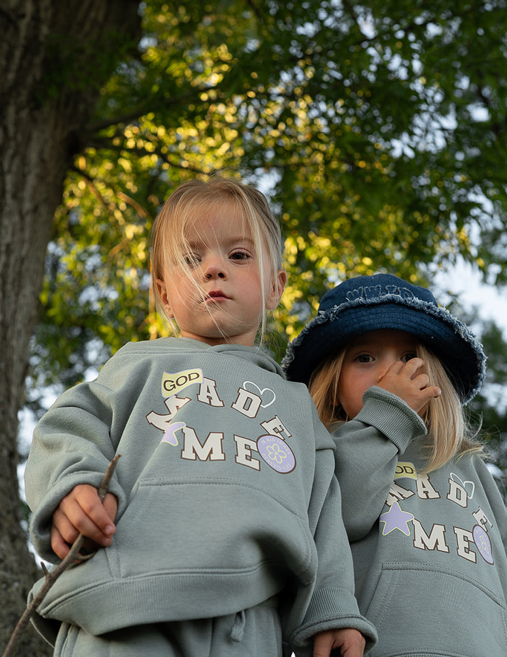 Kids sage green hoodie with "God Made Me" front graphic and hood pocket.