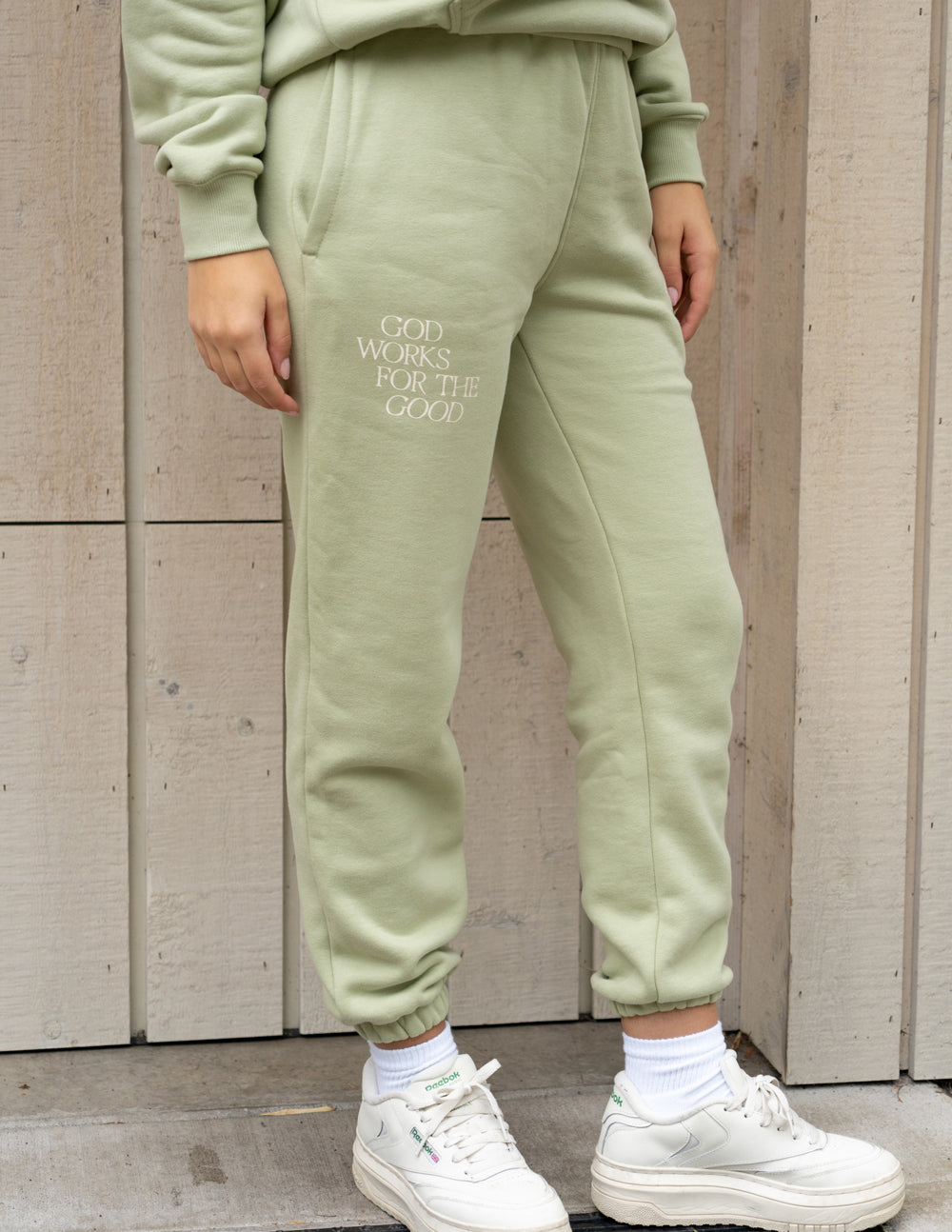 Light green unisex sweatpants with drawstring waist and front logo print
