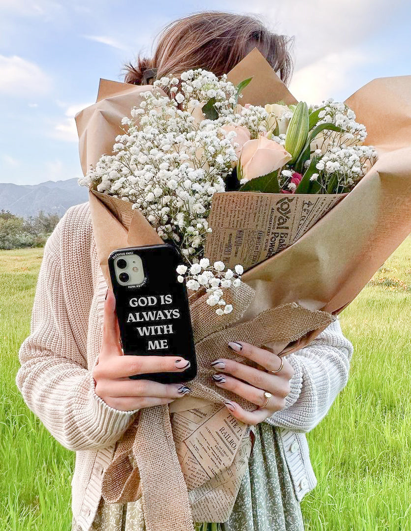 Black phone case with 'God is always with me' text, camera cutout visible.