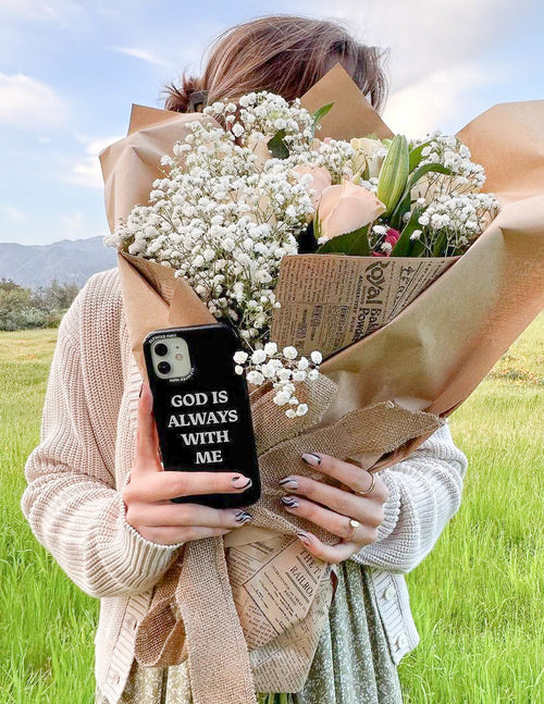 Black phone case with 'God is always with me' text, camera cutout visible.