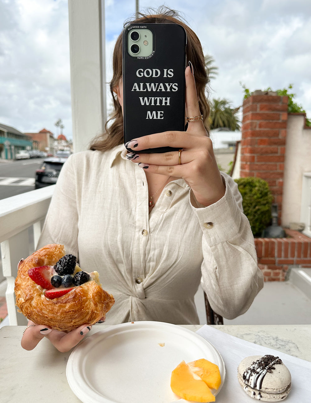Black phone case with 'God is always with me' text, camera cutout visible.