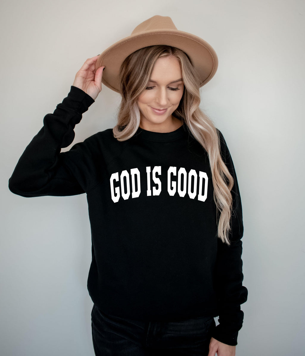 Unisex crewneck sweatshirt in black with "GOD IS GOOD" front graphic