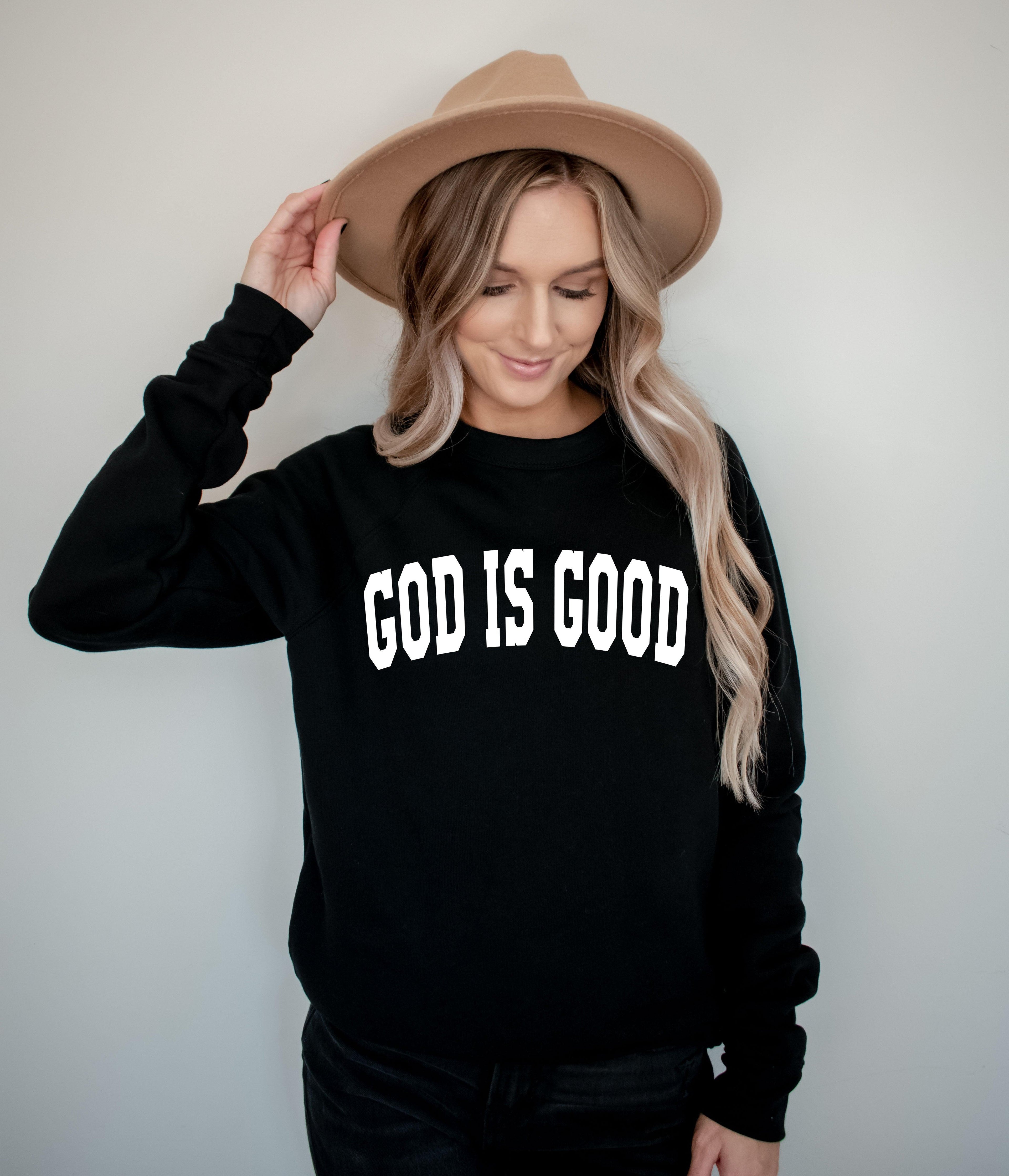 Unisex crewneck sweatshirt in black with "GOD IS GOOD" front graphic