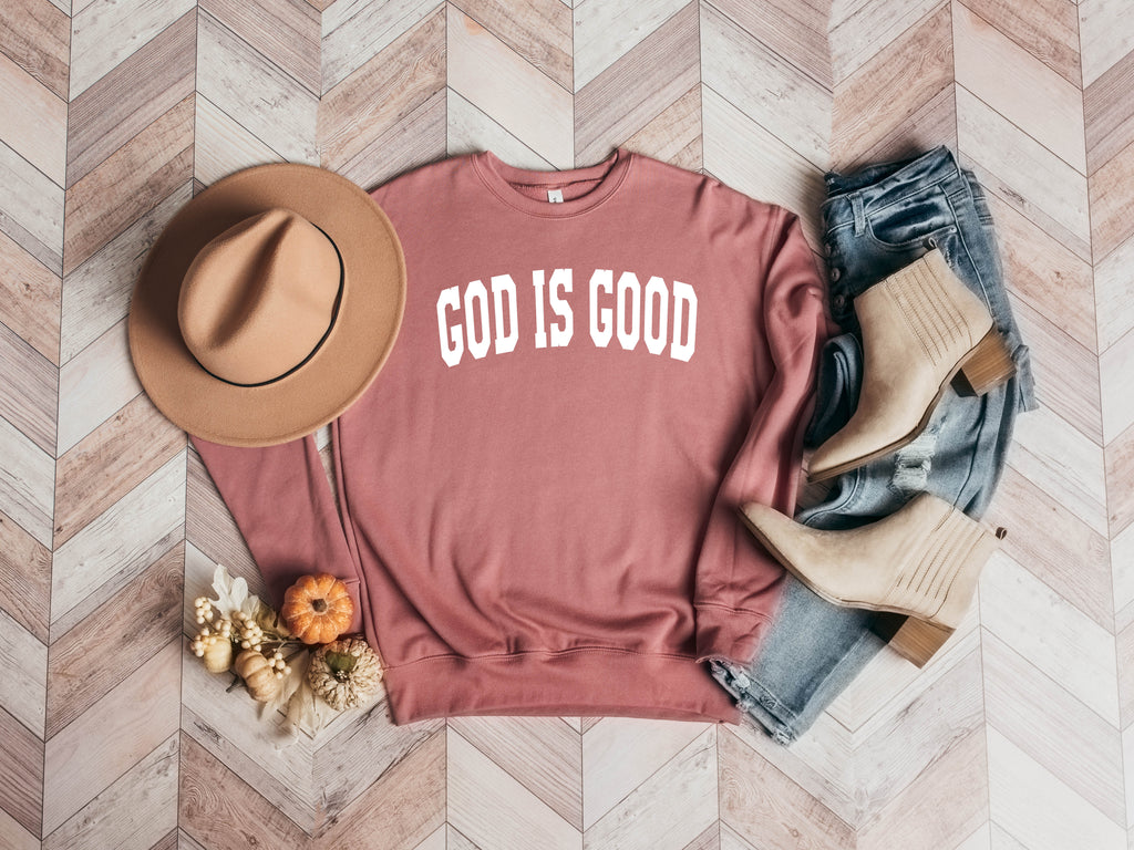 Unisex crewneck sweatshirt in mauve with "GOD IS GOOD" front graphic