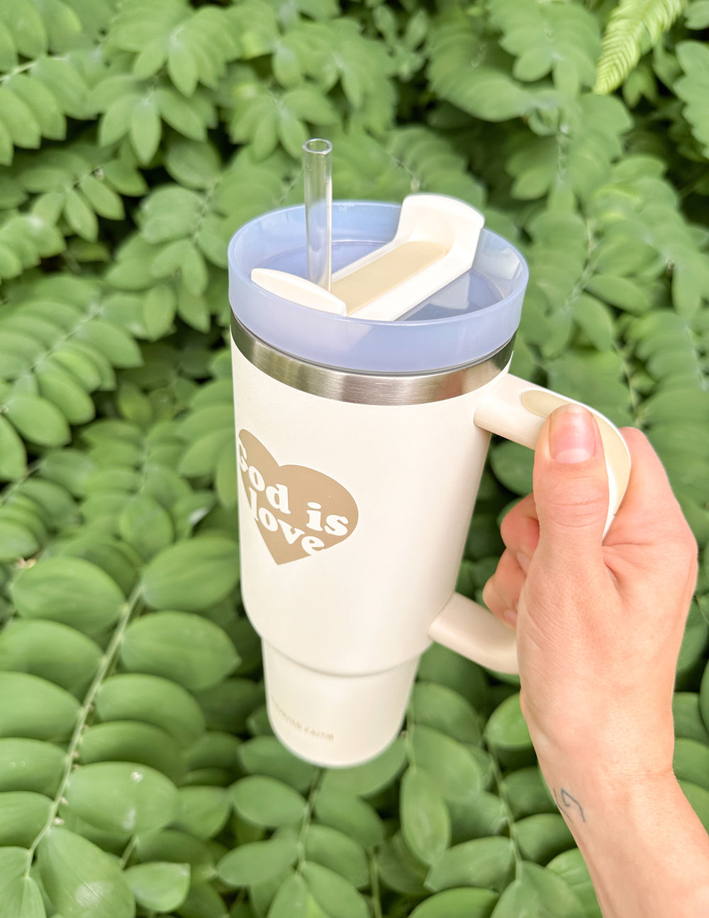 40 oz tumbler with straw and silver rim, cream body, "God is Love" heart print