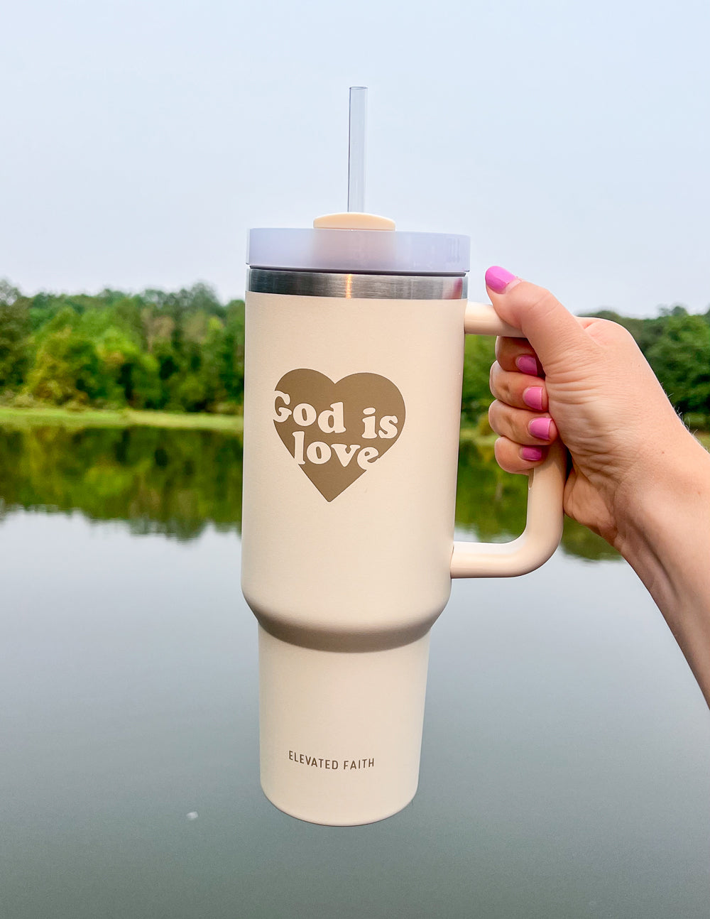 40 oz tumbler with straw, cream body, silver lid band, hand grip on handle