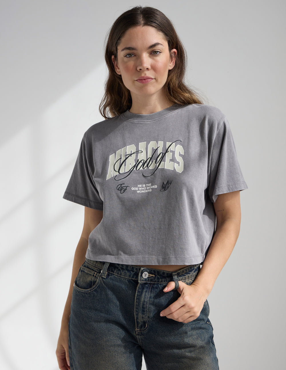 Cropped gray women’s tee with “Miracles” front print and tiny wording beneath