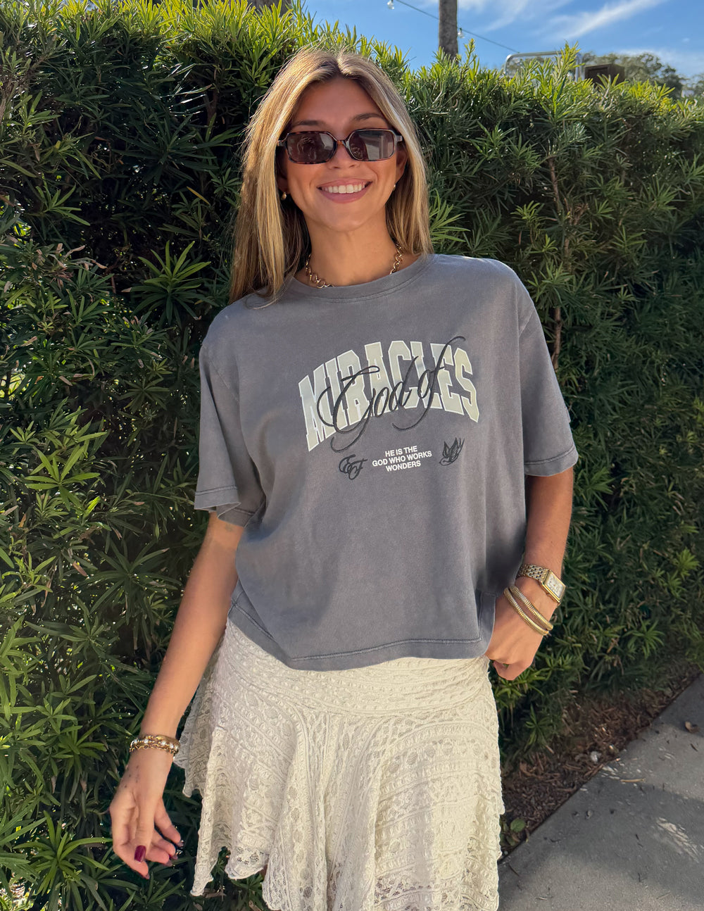 Cropped gray women’s tee with “Miracles” logo graphic on the chest
