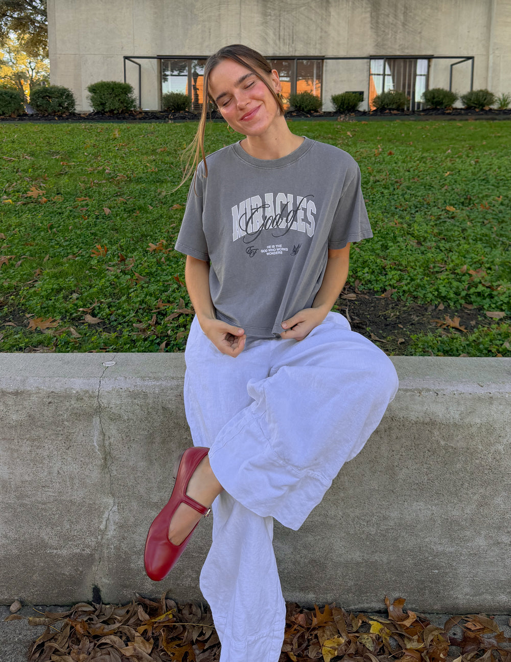 Cropped gray women’s tee with “Miracles” front print and small tagline beneath