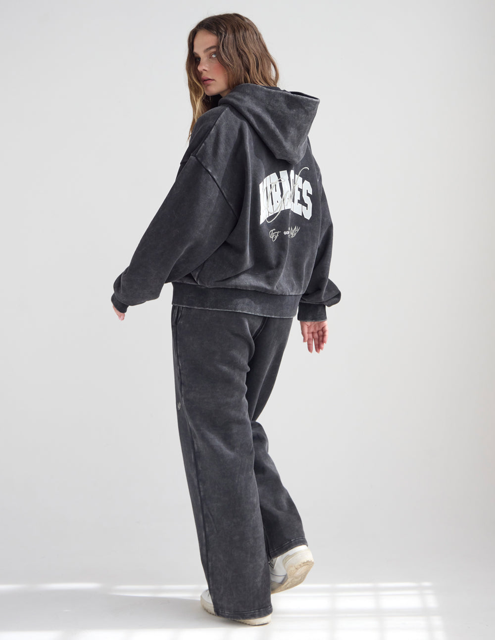 Dark charcoal full-zip hoodie with back wordmark and logo patch, hood up