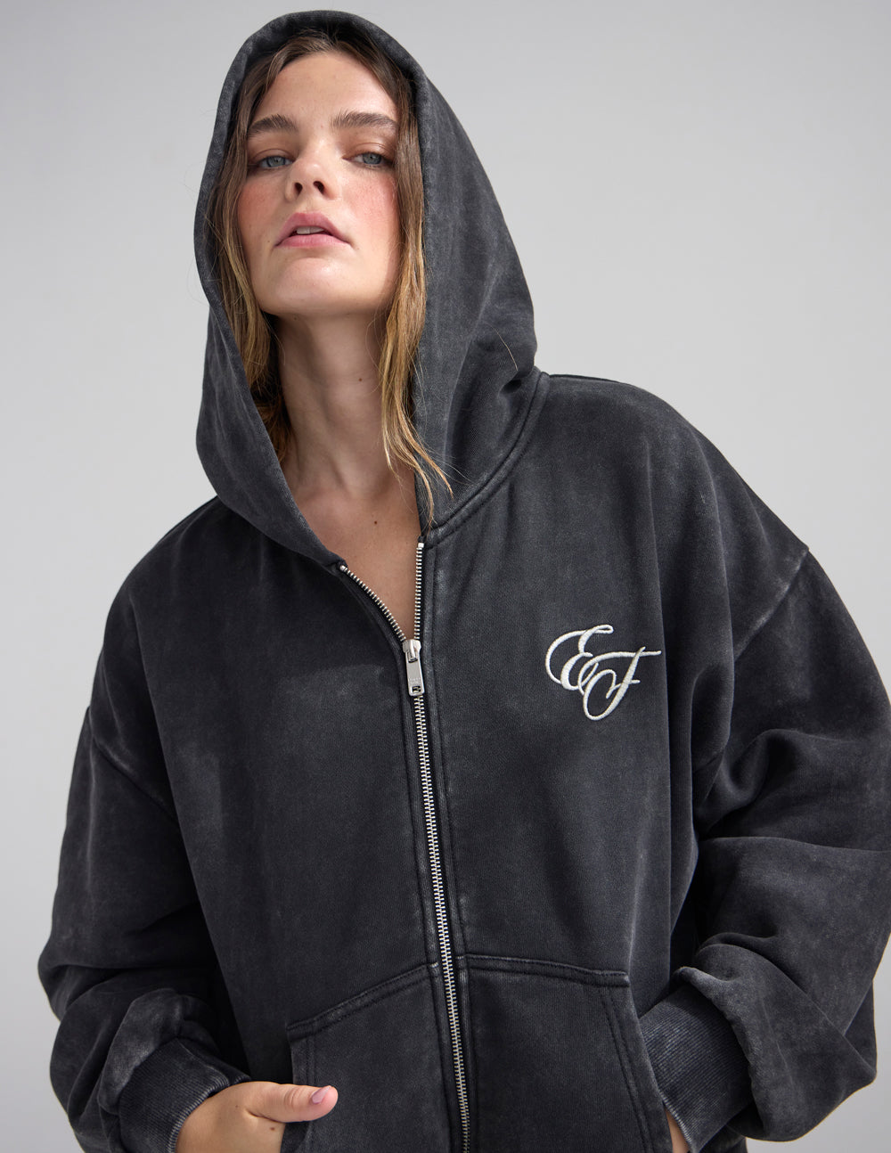 Dark charcoal hooded full-zip hoodie with front zipper and embroidered chest logo
