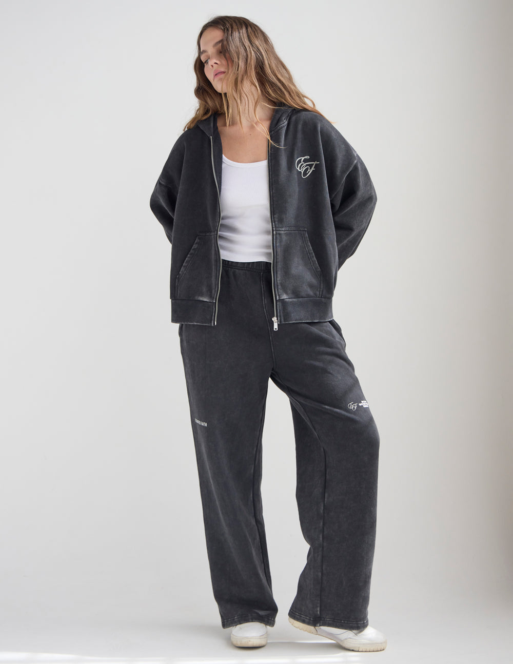 Dark charcoal full-zip hoodie with front zipper, front pockets, and chest logo