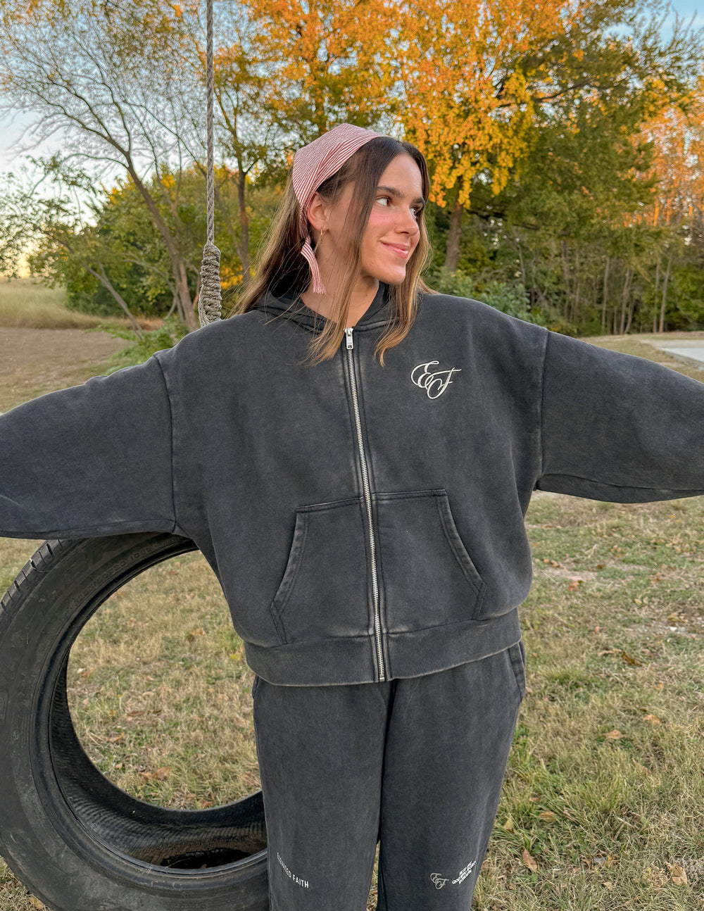 Dark charcoal full-zip hoodie with front zipper and small chest logo, hood down