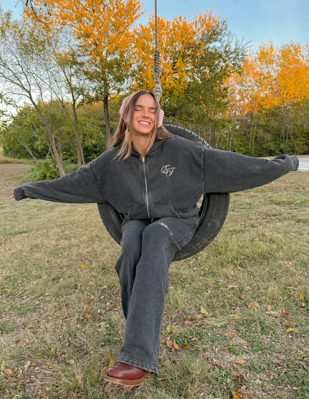 Charcoal full-zip hoodie with small chest logo and wide sleeves