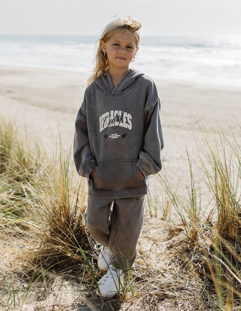 Kids dark gray hoodie with hood, long sleeves, chest graphic, and kangaroo pocket