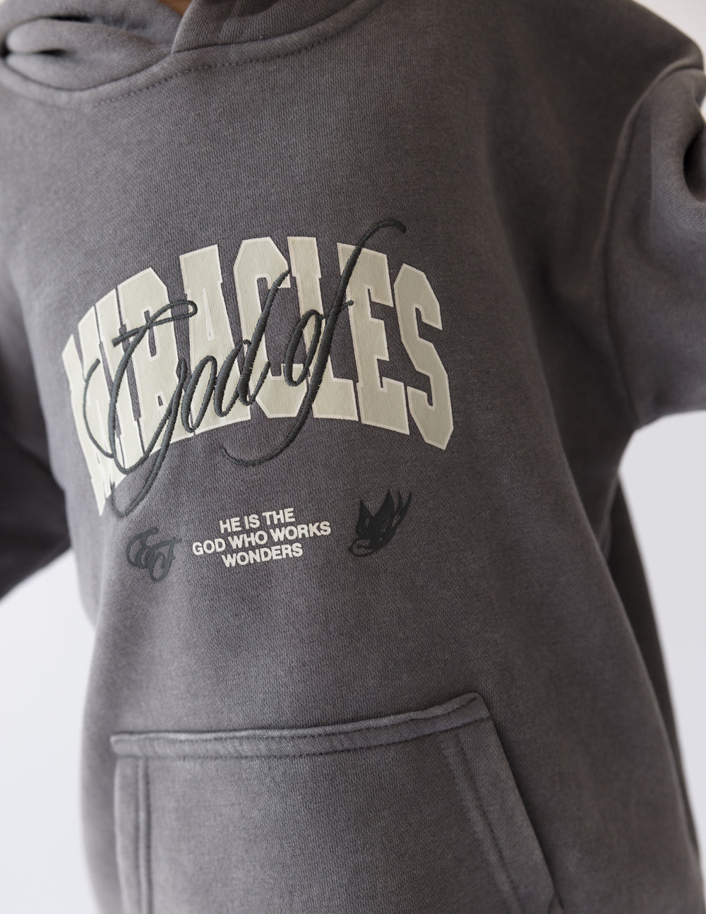 Kids dark gray hoodie close-up of chest graphic print and slogan beneath