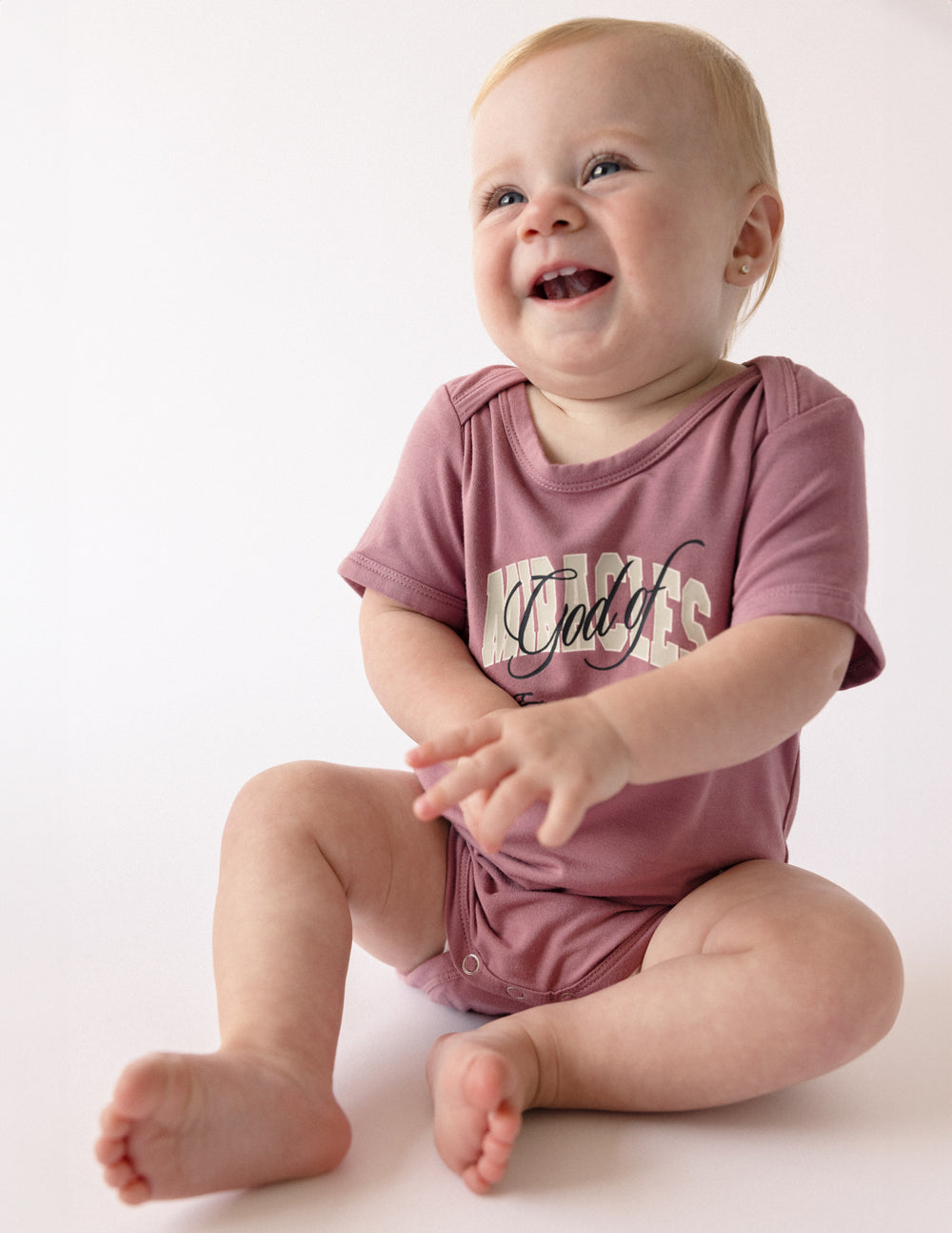 Mauve short-sleeve baby onesie with front graphic print and snap closure