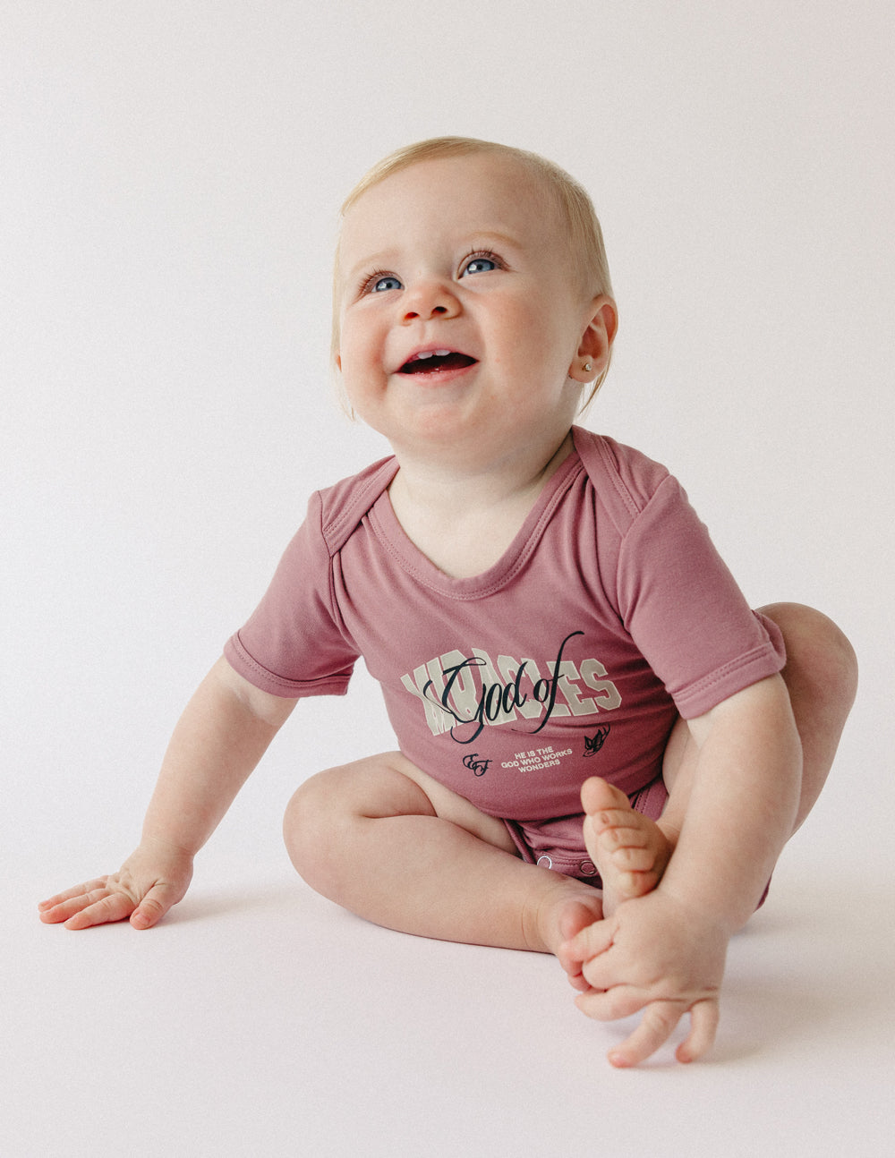 Mauve short-sleeve baby onesie with front graphic print and snap closure