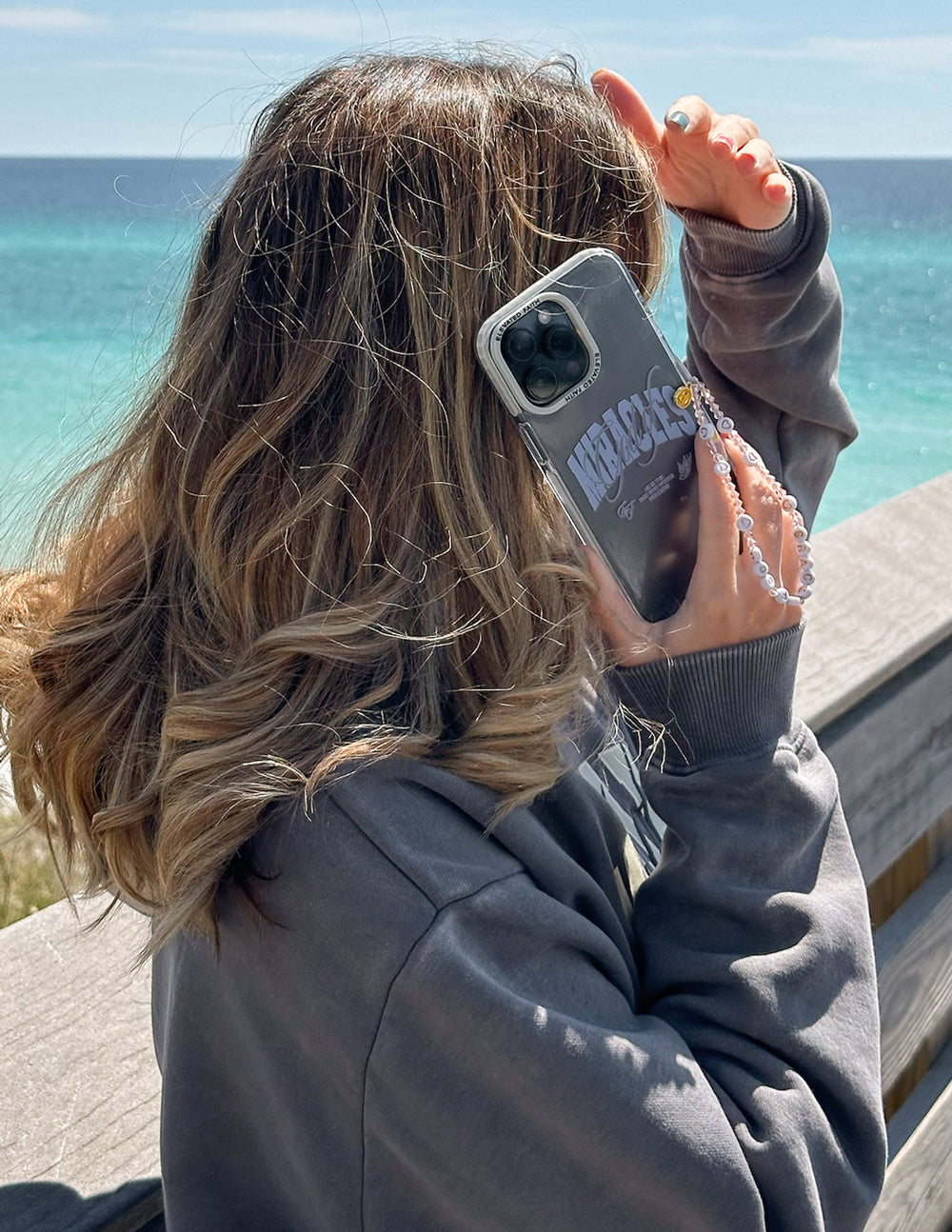 Gray phone case with blue “Miracles” graphic and clear edge bumper