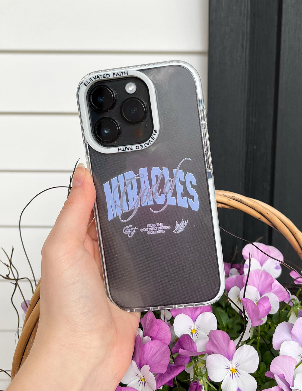 Dark phone case with blue “Miracles” lettering and clear side bumper