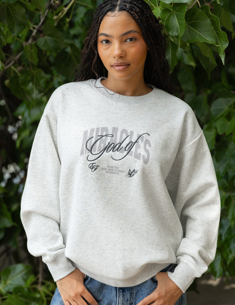 Heather gray unisex crewneck sweatshirt with front graphic logo, worn on model.