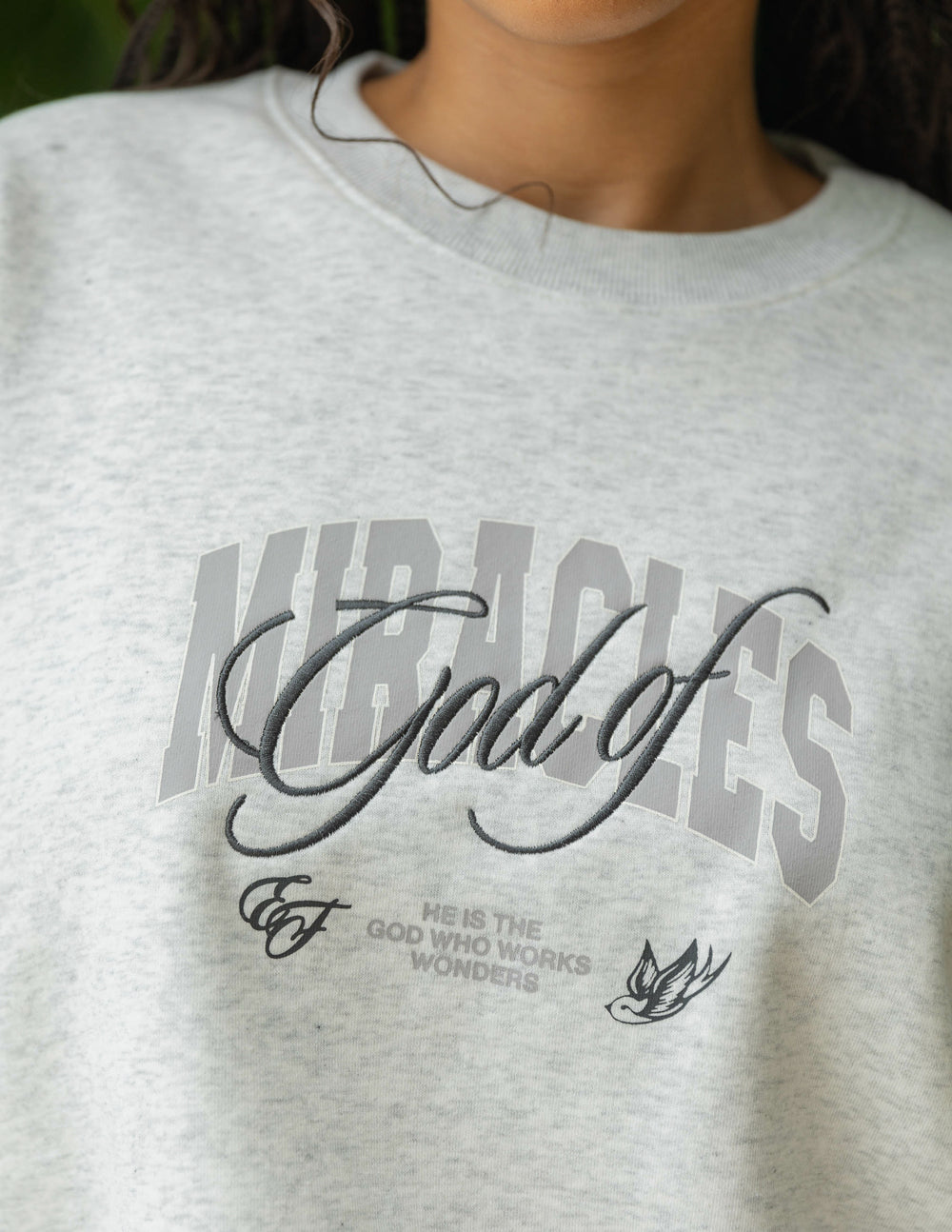 Heather gray unisex crewneck sweatshirt close-up of front graphic logo.