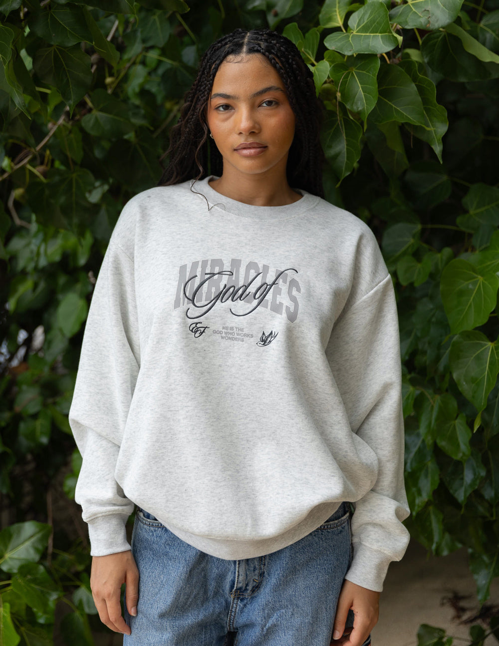 Heather gray unisex crewneck sweatshirt with front graphic logo, paired with jeans.