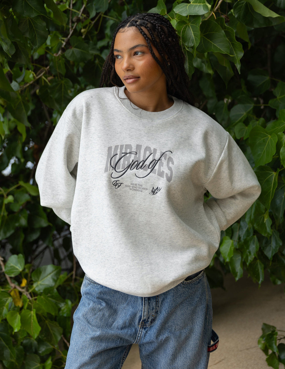 Heather gray unisex crewneck sweatshirt on model, front graphic logo visible.