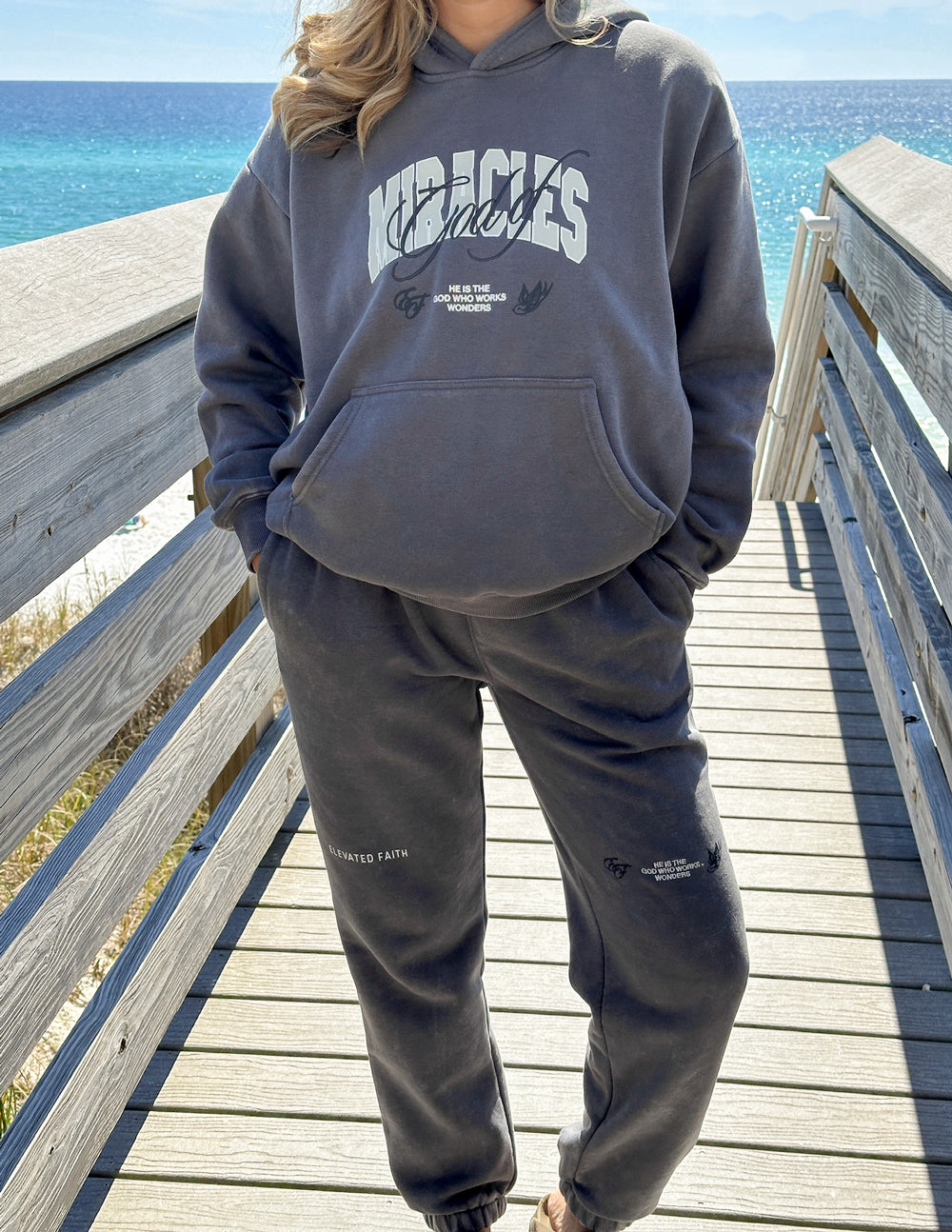 Dark gray unisex sweatpants with elastic waistband and leg logo, cuffed jogger style