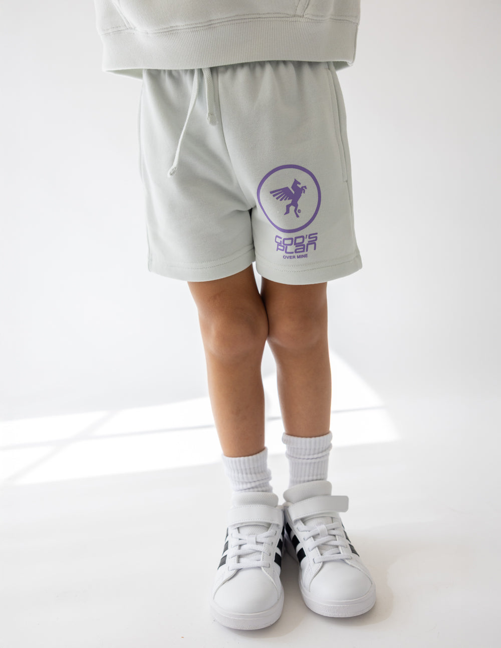 White kids racing shorts with purple back logo and drawstring waistband