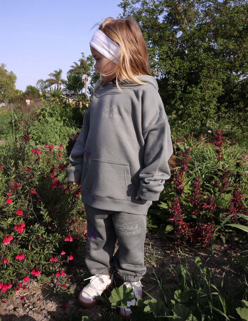 Kids gray hoodie with hood and back verse text, worn with matching joggers