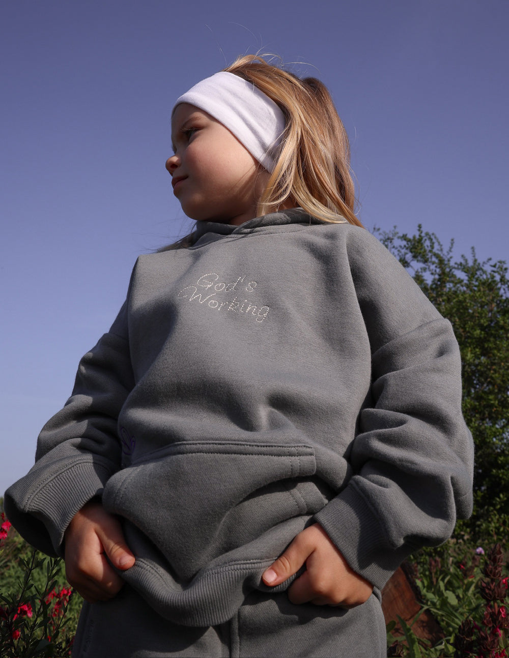 Kids gray hoodie from back, large floral text graphic, kangaroo pocket.