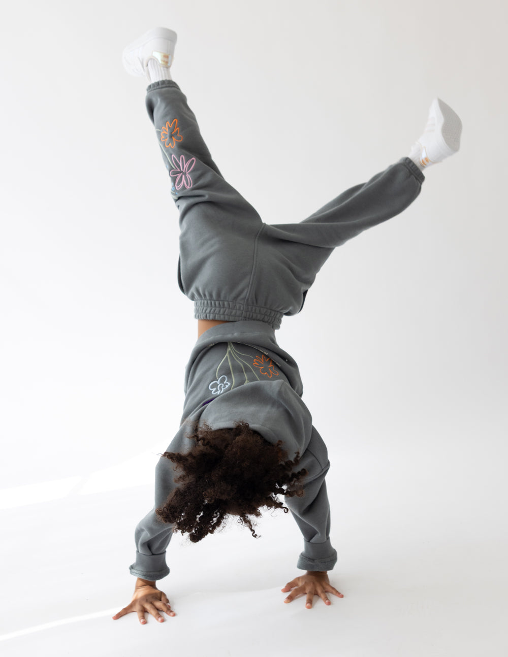 Kids gray sweatpants with elastic cuffs and embroidered flowers on legs