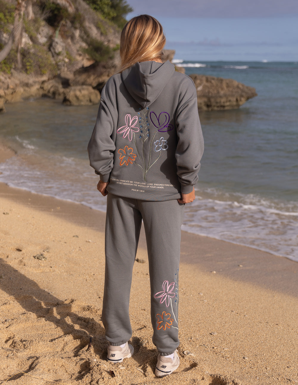 Gray unisex hoodie with colorful floral graphic on the back and hood.