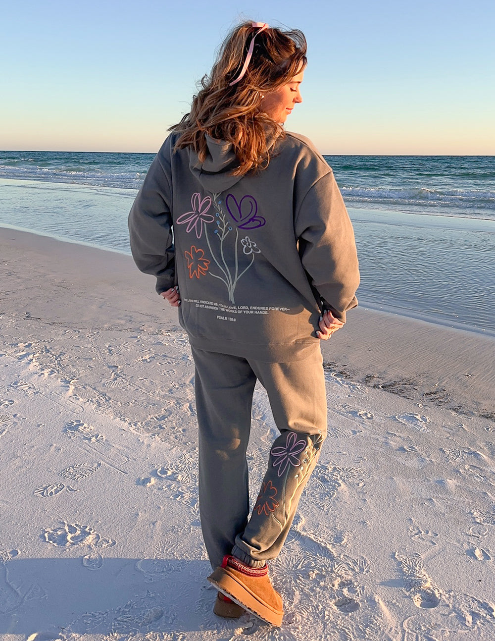 Gray unisex hoodie with back floral text graphic, hood, and front pocket.