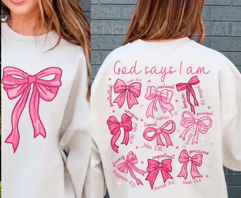 Cream sweatshirt with large pink bow graphic and “God says I am” text