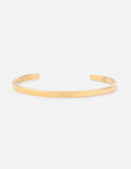 Gold cuff bracelet with engraved linear lettering detail