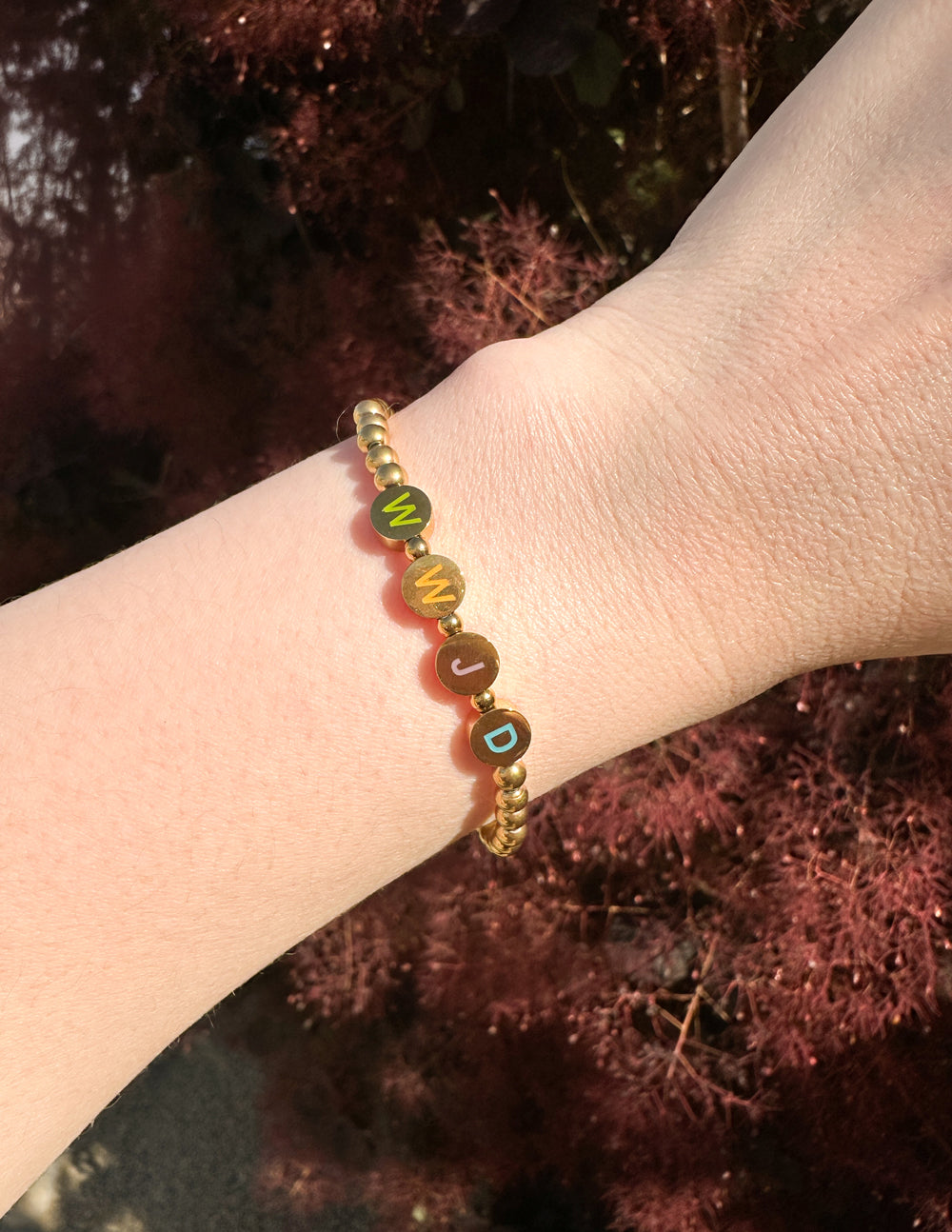 Gold beaded letter bracelet with colorful letter disks and small charm beads
