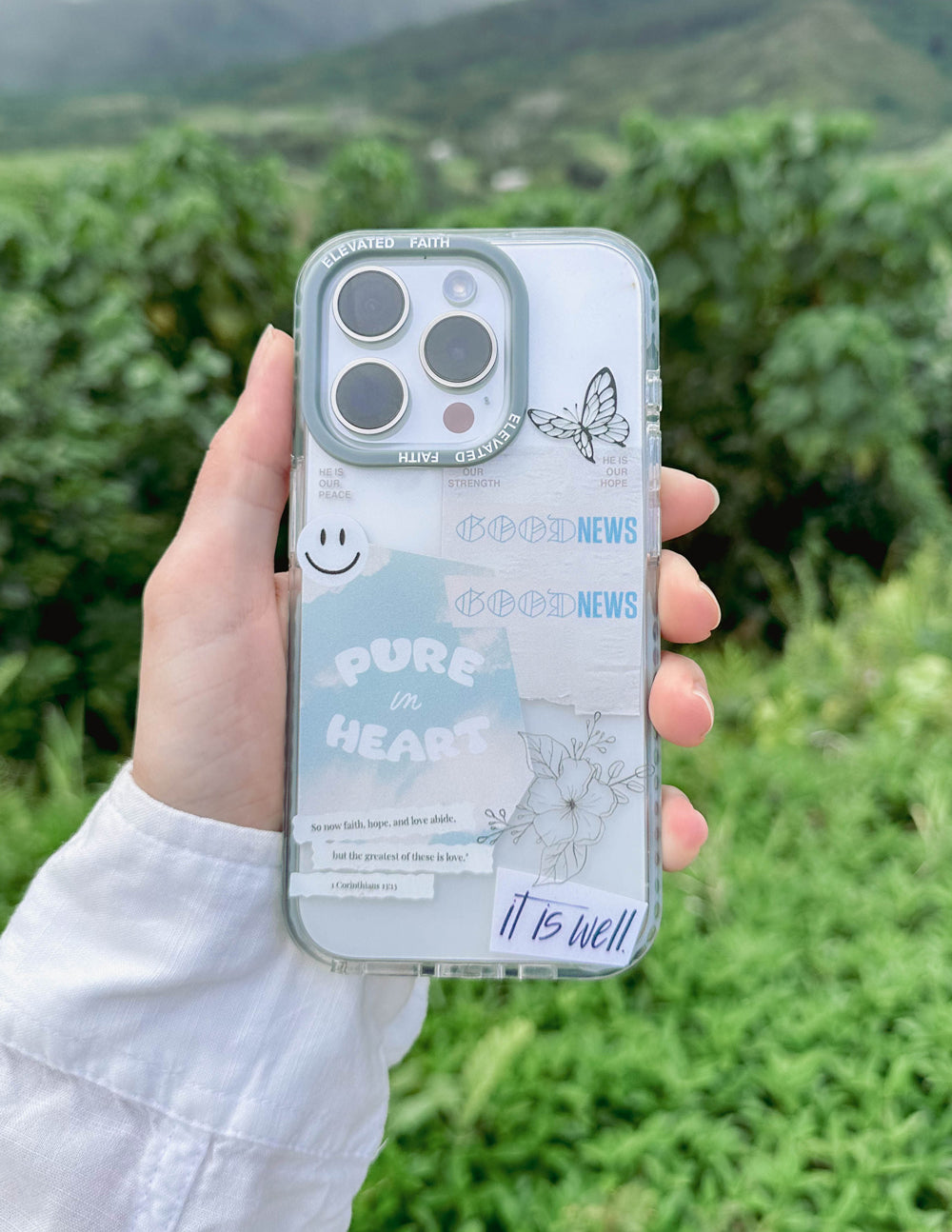 Transparent phone case with light blue border, butterfly and 'It is well' style footer