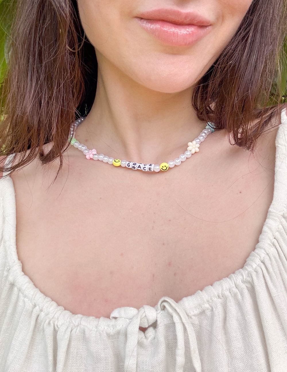 Grace letter necklace with white bead chain and “GRACE” letter charms with pastel smileys