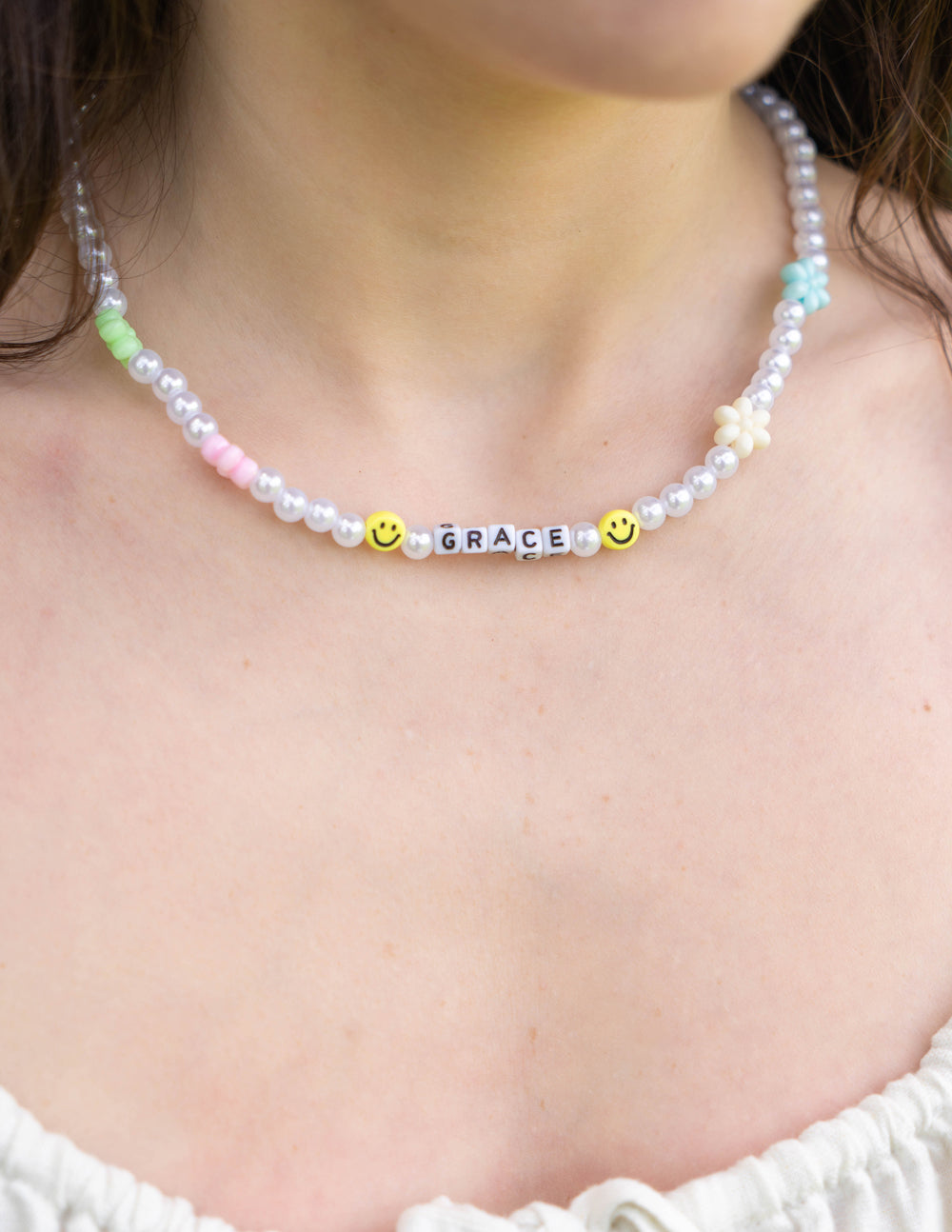 Grace letter necklace with white pearl beads, “GRACE” letters, and yellow smiley accents
