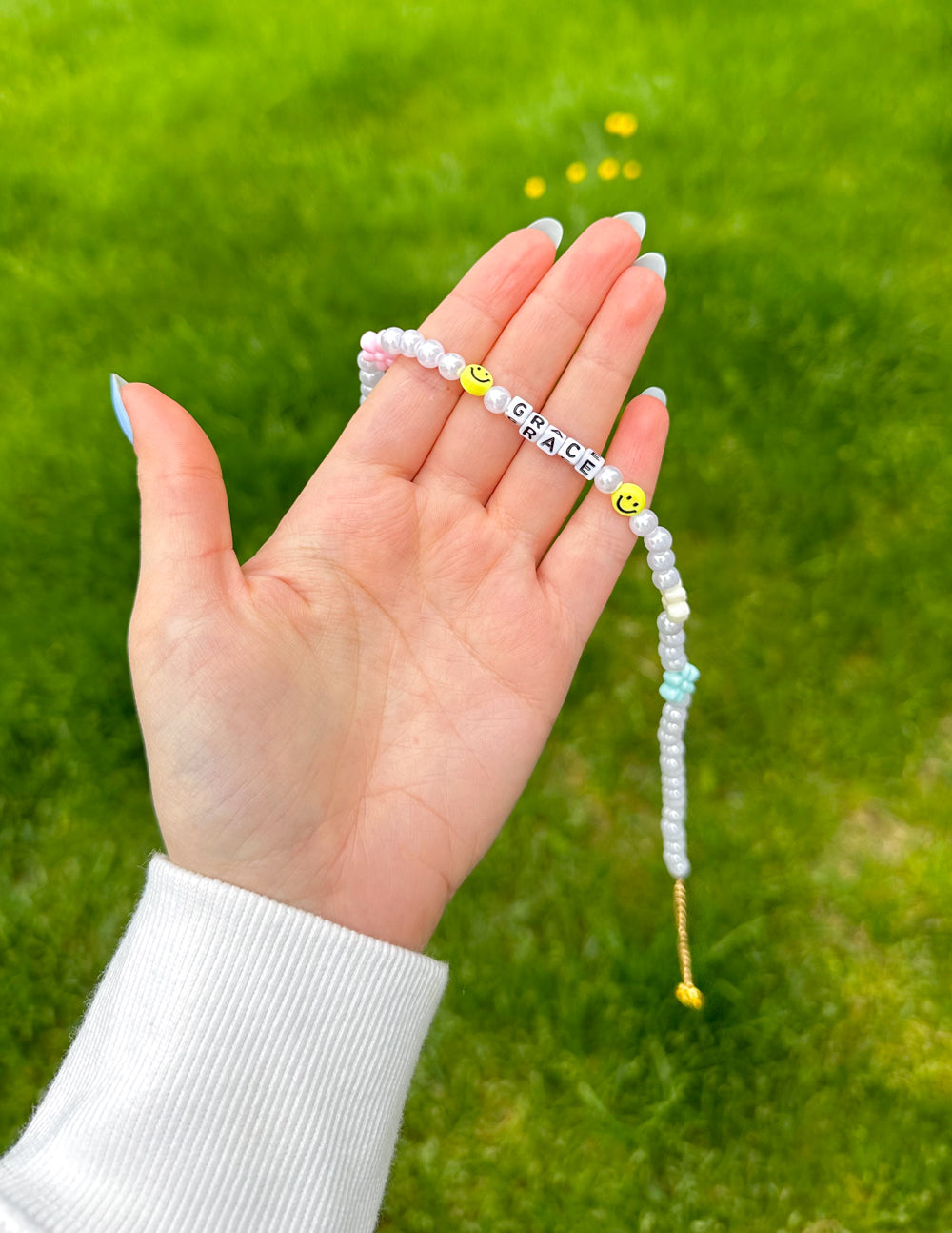 Grace letter necklace with white pearl strands, “GRACE” beads, and a small hanging tassel