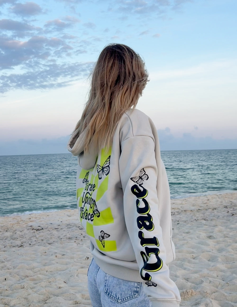 Cream unisex hoodie back with butterfly and script graphic, long sleeve print detail