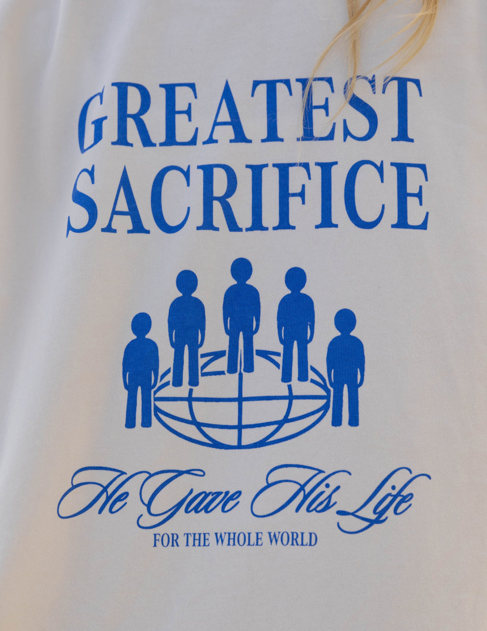 Close view of white long-sleeve T-shirt with blue text and figure graphic