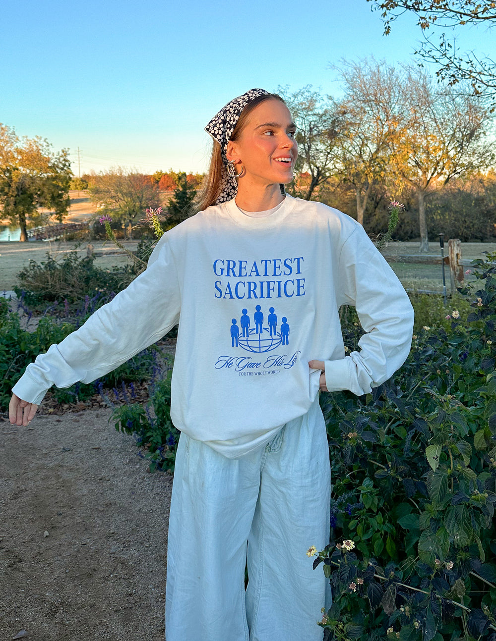 White long-sleeve unisex T-shirt with blue “Greatest Sacrifice” graphic front