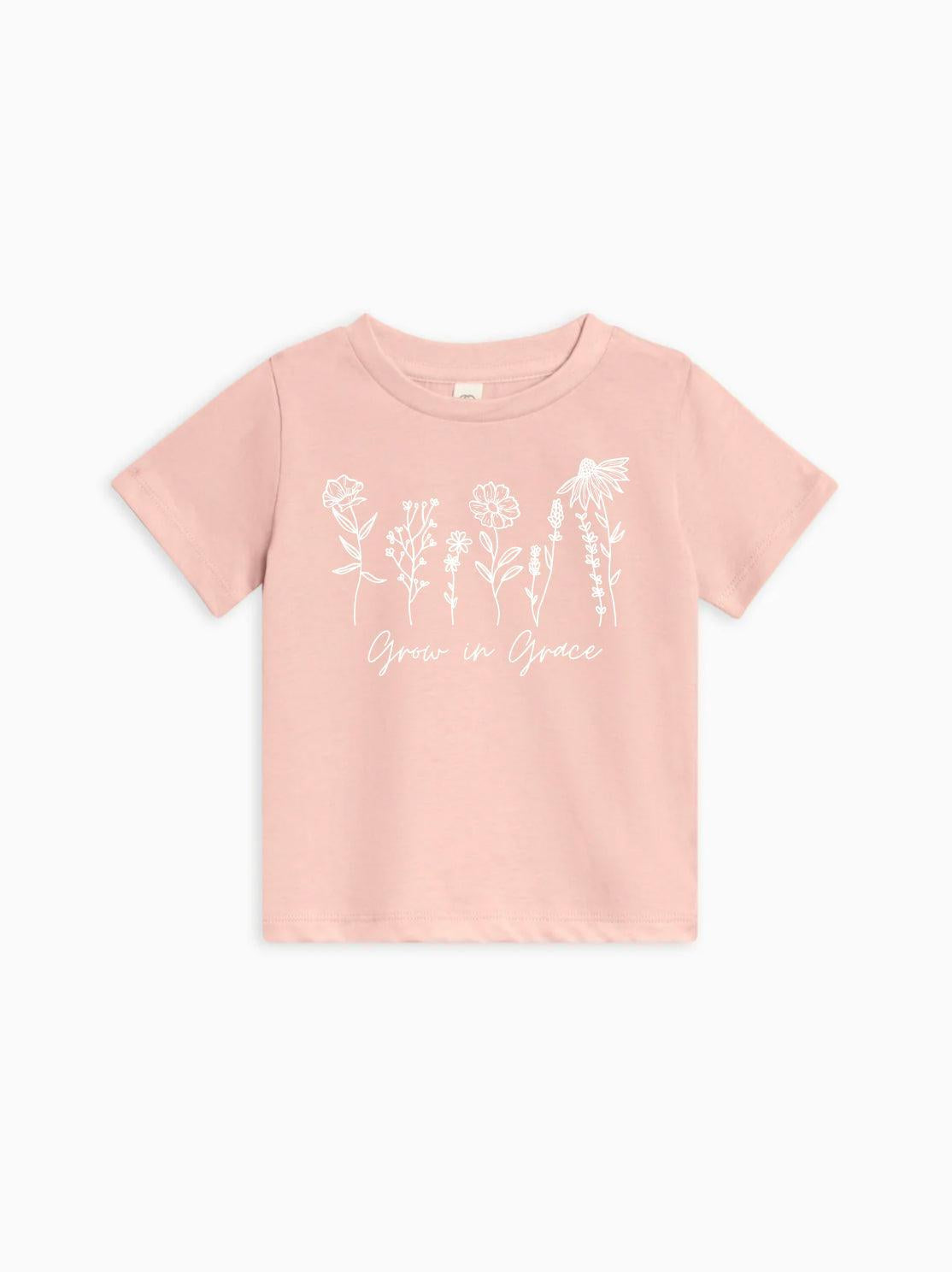 Kids organic cotton T-shirt in ballet pink with white wildflower graphic and Grow in Grace text.